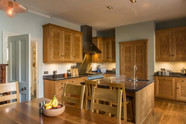 Kitchen with oak cabinets, granite worktops, kitchen island & handmade oak trestle table