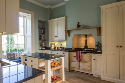  wide view of kitchen showing Aga range, Larder cupboard, mobile kitchen island and window seat